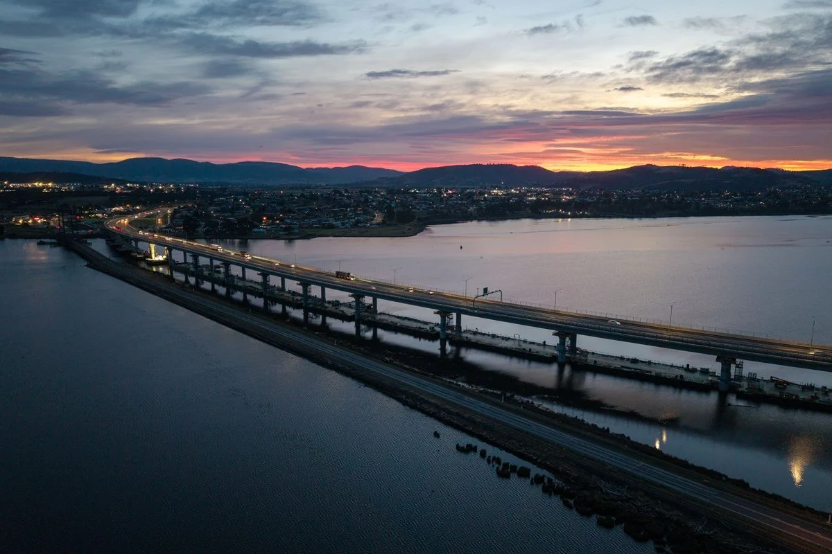 Cars drive over the new Bridgewater Bridge at sunset