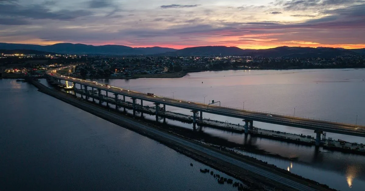 Cars drive over the new Bridgewater Bridge at sunset